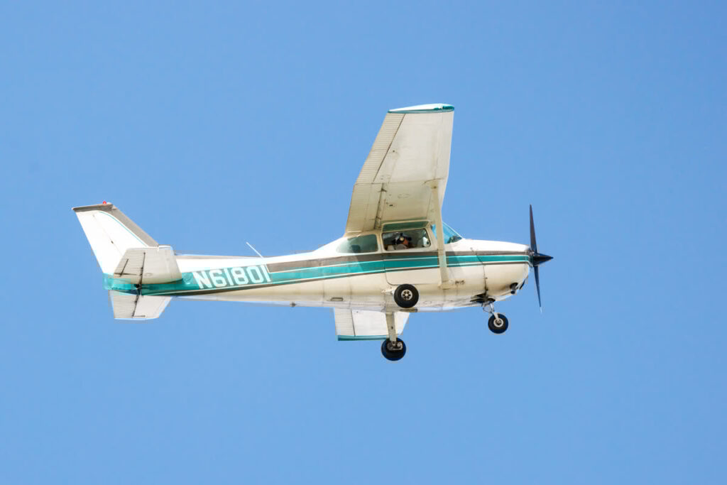 Mote's Kerri Scolardi rides in a small airplane, seen flying above at a distance. She counts manatees in the waters below during an aerial survey to help estimate abundance.