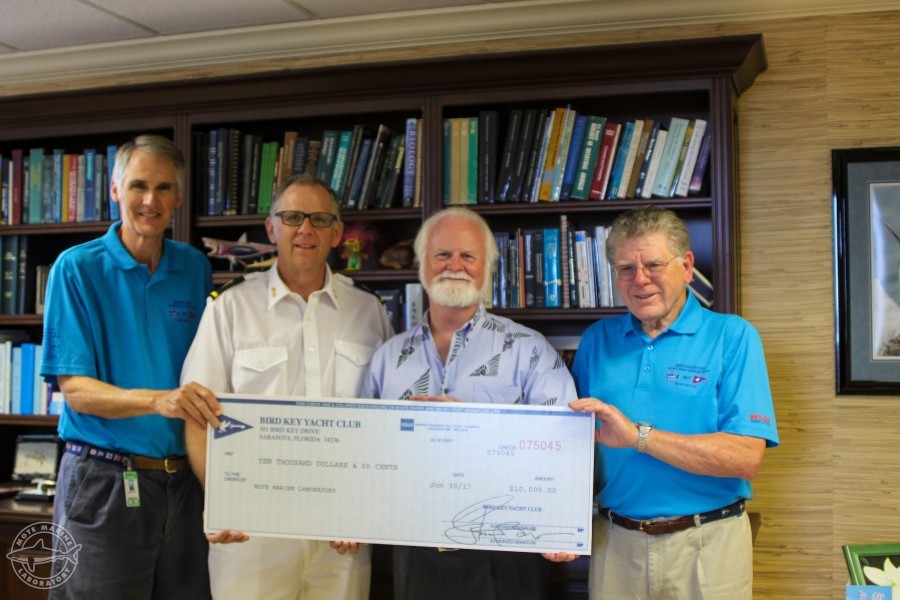 Dr. Michael P. Crosby receives donation check from Jon Turner, Bob Williams and Bill Jacobs of Bird Key Yacht Club.