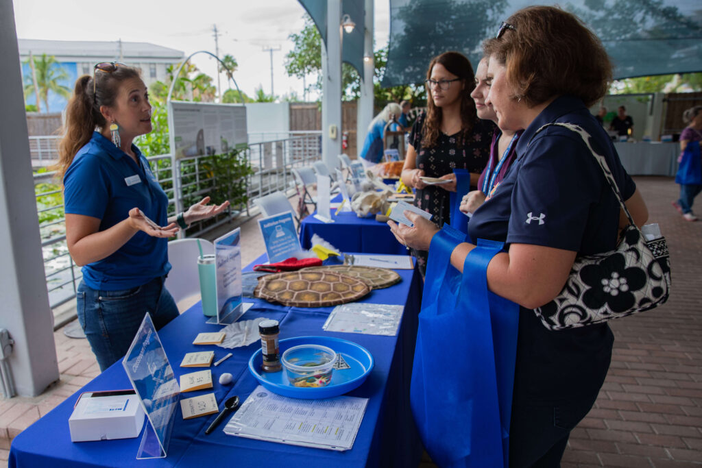 Mote staff member Alison Goldy speaks to attendees at the 2022 Educator Open House about classroom program opportunities.