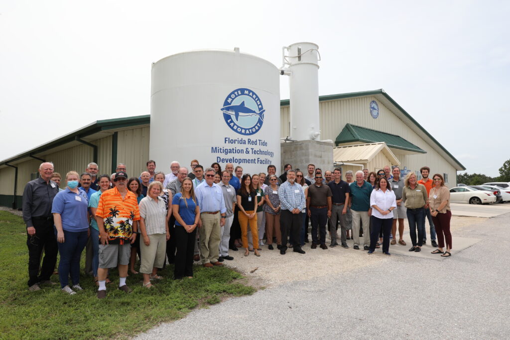 Participants of the red tide mitigation tools workshop standing in front of the Mote Florida Red Tide Mitigation & Technology Development Facility