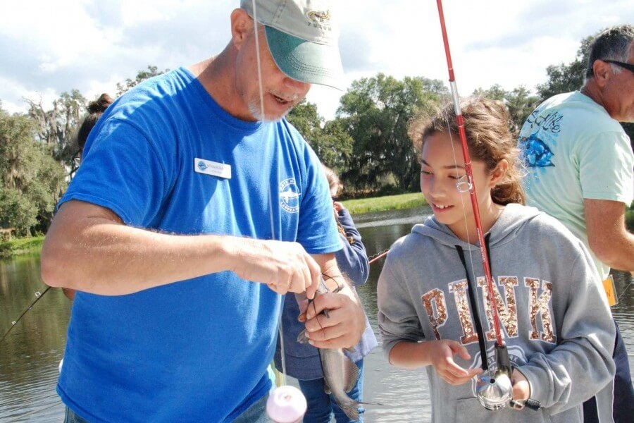 Mote's Dr. Nathan Brennan shows a Brentwood Elementary student how to fish. Credit: Mote Marine Laboratory