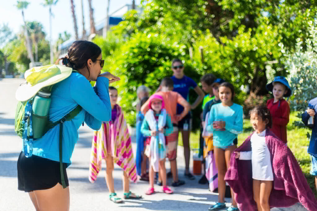 A Mote educator mimes an animal behavior to a group of young children.