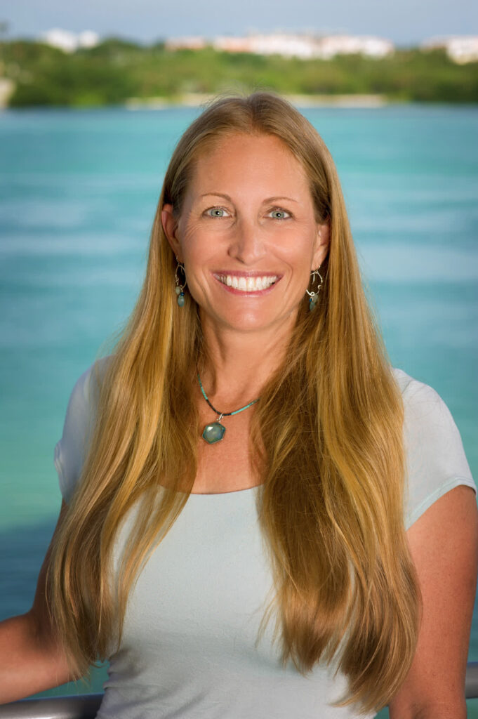 Portrait of Kim Bassos-Hull, standing in front of the bay.