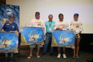 The Humpty Dumpty lionfish fishing team grin broadly in matching shirts as Mote staff present them with the first place award of lionfish paintings.