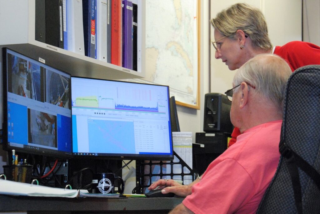 Mote scientists and volunteers review and analyze fisheries electronic monitoring videos and data in the Center for Fisheries Electronic Monitoring at Mote (CFEMM) lab. Oct. 15, 2019. Pictured (standing): Carole L. Neidig, M.Sc., Staff Scientist in Mote's Directorate of Fisheries and Aquaculture. Photo by: Hayley Rutger/Mote Marine Laboratory.