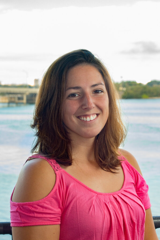 Portrait of Dr. Heather Page, smiling at the camera in front of the bay.