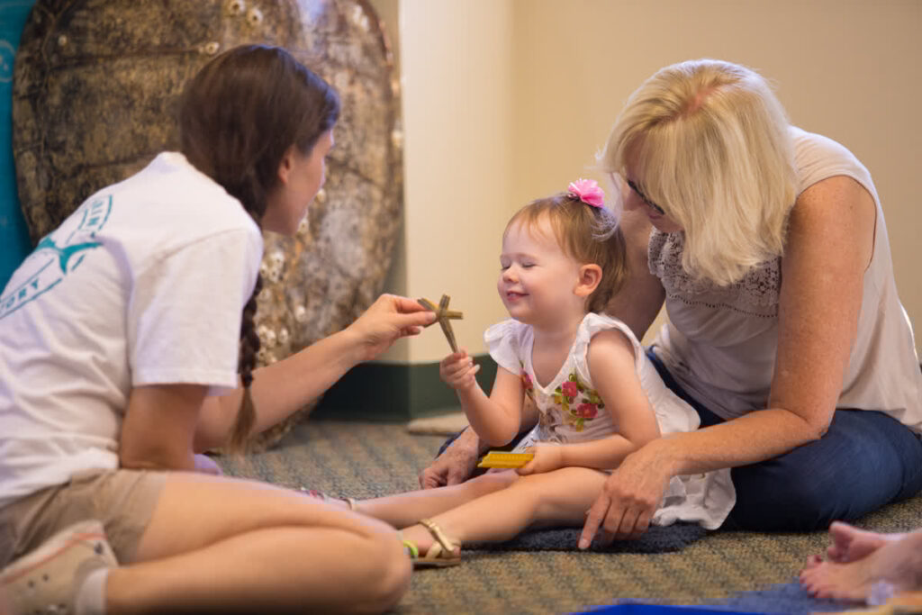 Mote Staff Member Shows Sea Star To Child And Grown Up