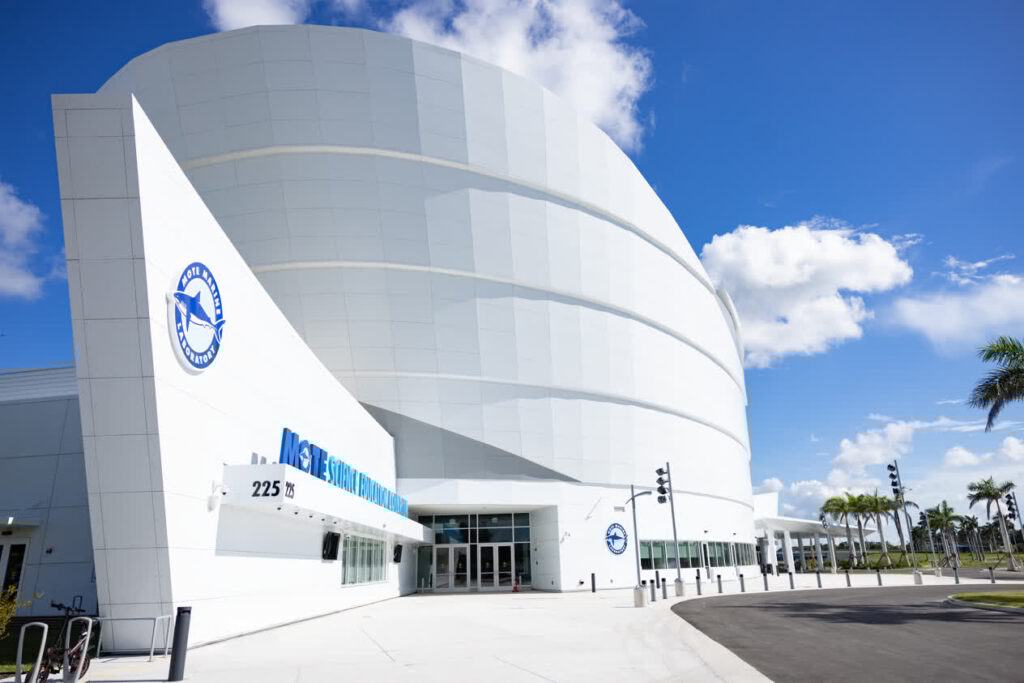 Photo: The entrance to Mote Science Education Aquarium, a modern building with sweeping lines in front of a bright blue sky