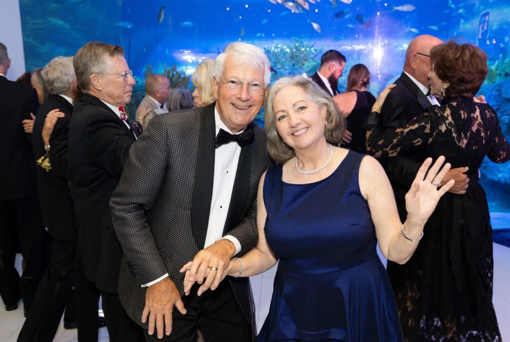 Two guests dancing in front of an exhibit at Mote's Oceanic Evening